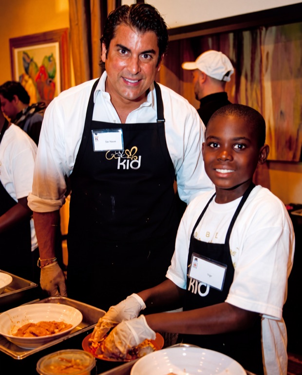 Otto E. Berges cooking alongside a child at the Cooking with KID event